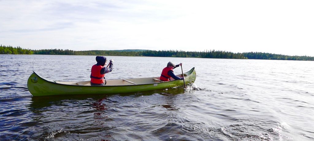 Två barn i en kanot på en sjö