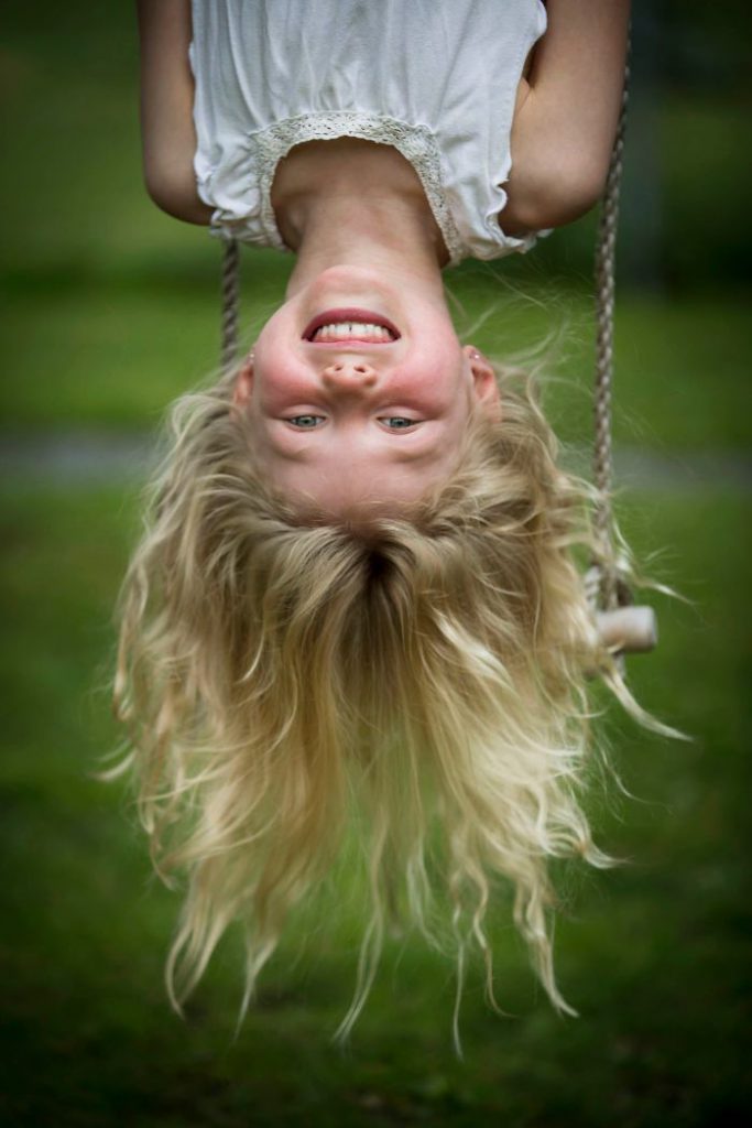 En flicka hänger upp och ner i en repstege