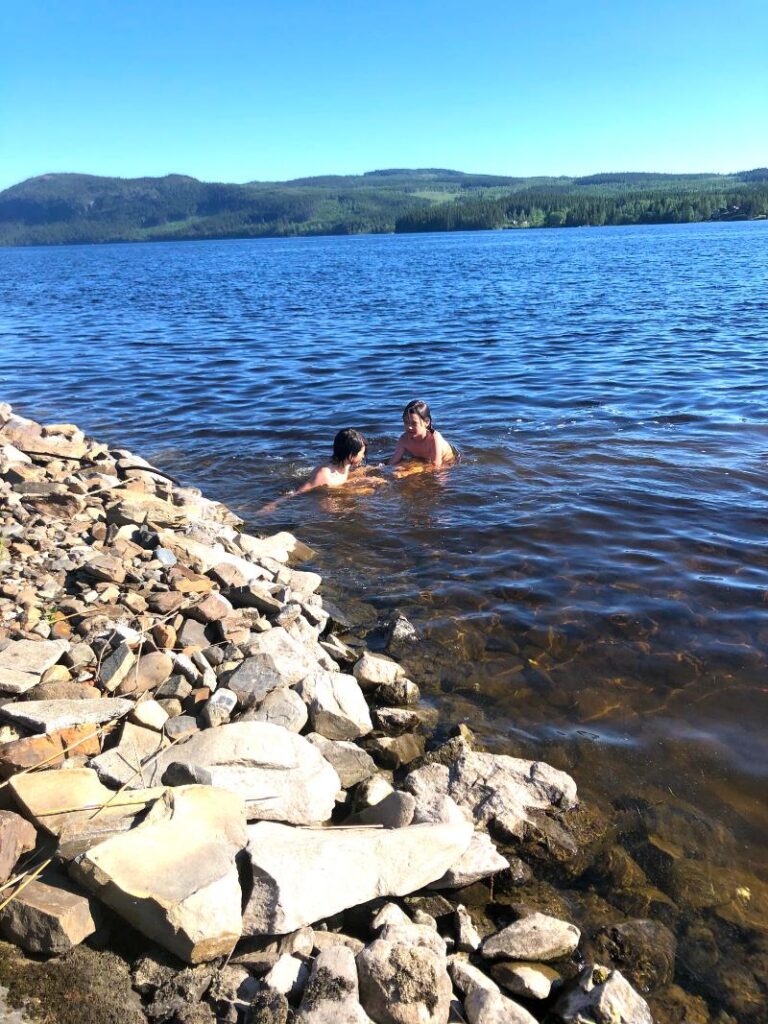 Barn badar i sjön Hällsjön en solig sommardag